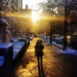 Rear view of woman on street in city during winter