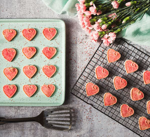Top view of valentine's day heart cookies cooling on pan and rack.
