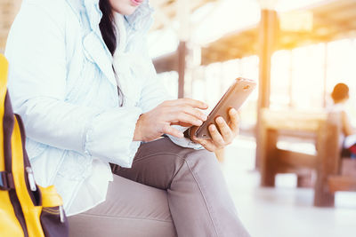 Midsection of woman using mobile phone