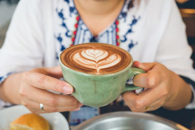 Midsection of woman holding coffee cup