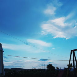 Low angle view of power lines against blue sky