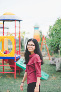 Smiling young woman standing at playground