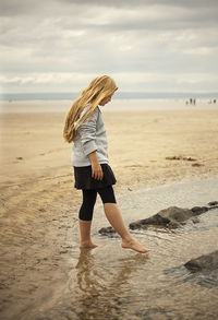 Full length of woman on beach against sky