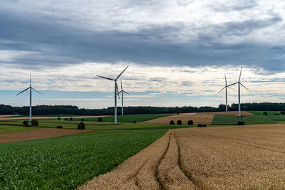 Scenic view of agricultural field against cloudy sky