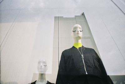 Portrait of man standing against glass wall