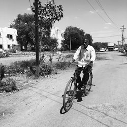 Full length of boy riding bicycle on road