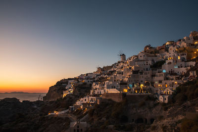 Buildings in town against sky during sunset