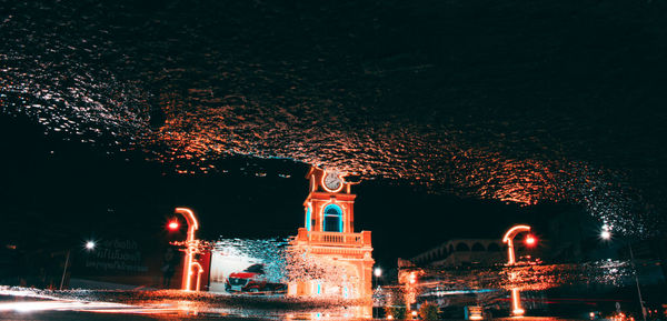 Illuminated building by street at night