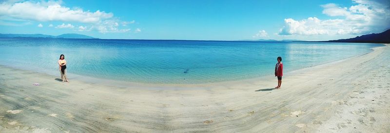 People standing on beach against sky