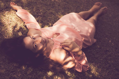 Portrait of young woman lying at park