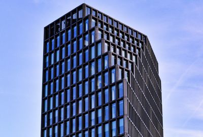 Low angle view of modern building against blue sky