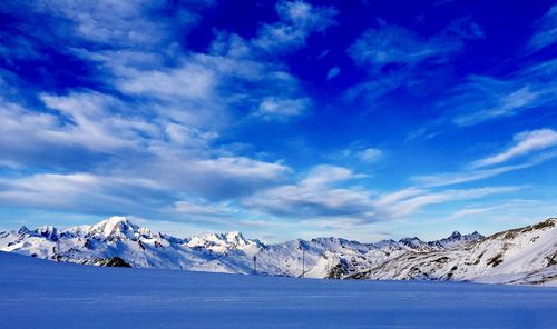 Scenic view of snowcapped mountains against blue sky