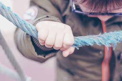 Close-up of boy holding rope