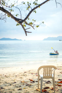 Empty chair on sand at beach