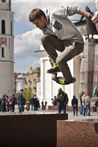 Young man jumping over seat in city
