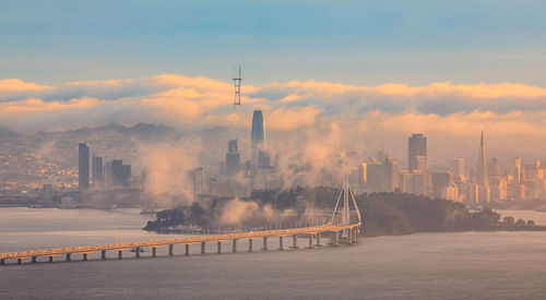 Bridge over river against sky during sunset