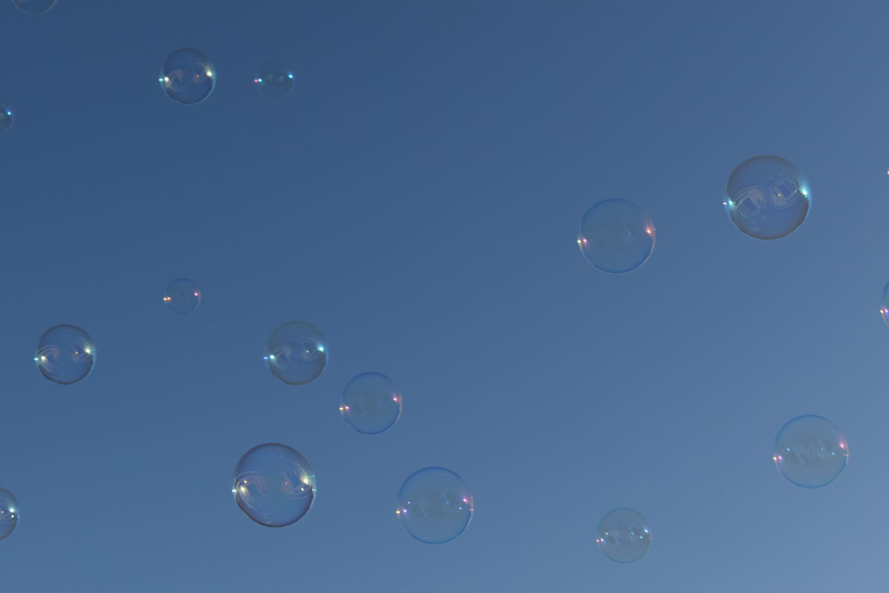 LOW ANGLE VIEW OF BUBBLES AGAINST MOON IN SKY