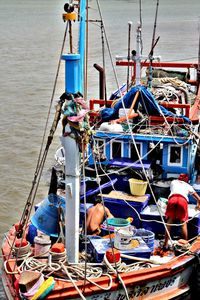 People working on boats moored in sea