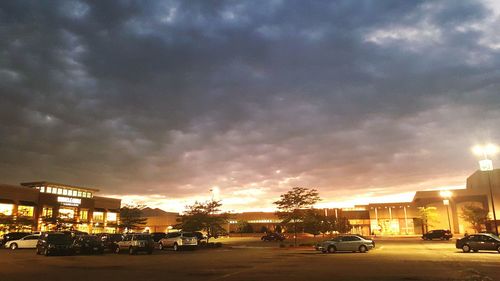 Cars on road against cloudy sky