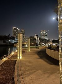 Illuminated bridge by city against sky at night