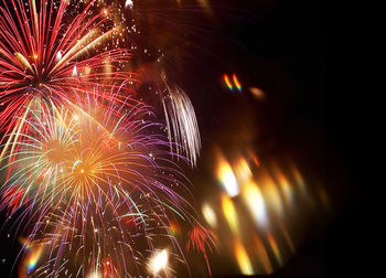 Low angle view of firework display at night