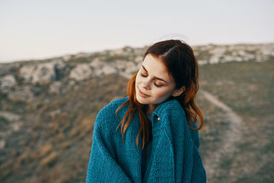 Portrait of beautiful young woman against sky