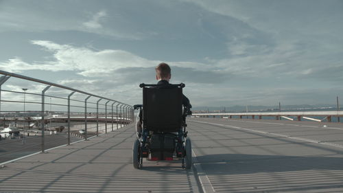 Rear view of boy sitting on wheelchair