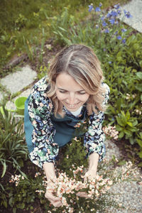 High angle view of young woman standing amidst plants