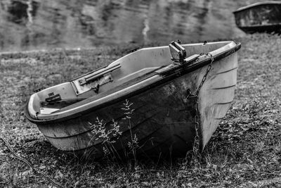 Abandoned boat moored on field