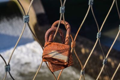 Close-up of rusty padlocks on chainlink fence