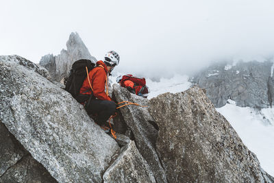 Climber securing his partner on thin ridgeline near mont blanc