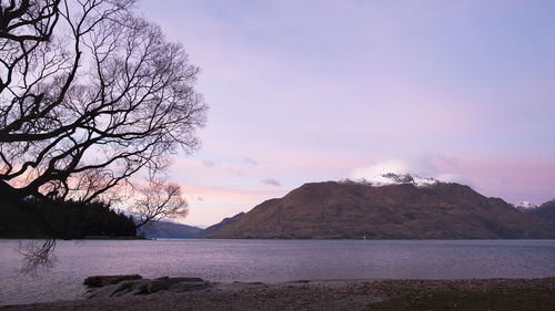 Scenic view of lake and mountains against sky during sunset