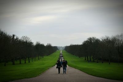 Rear view of people walking on footpath in park