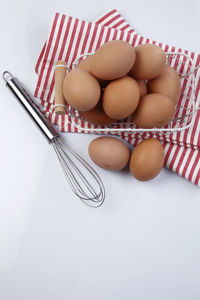 Close-up of eggs in basket against white background