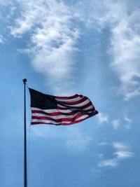 Low angle view of american flag against blue sky