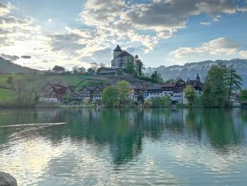 Scenic view of lake by buildings against sky