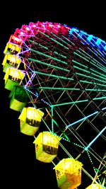 Low angle view of illuminated ferris wheel at night