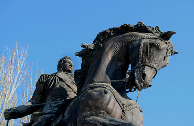 Low angle view of statue against clear blue sky