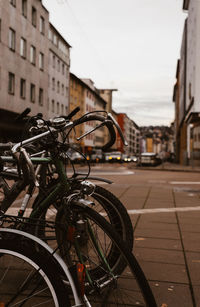 Bicycles parked in city against sky