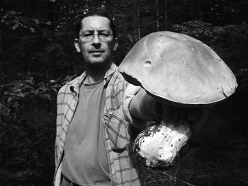 Portrait of mature man holding large mushroom