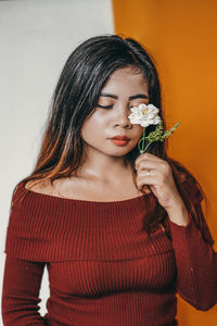 Close-up of a beautiful young woman with white flower