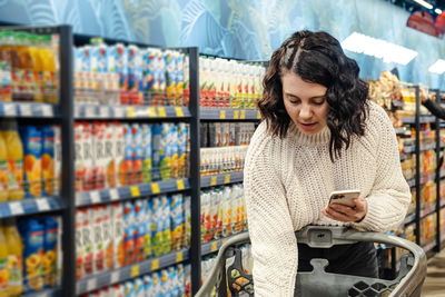 Portrait of young woman standing in supermarket