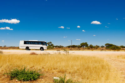 Scenic view of bus against blue sky