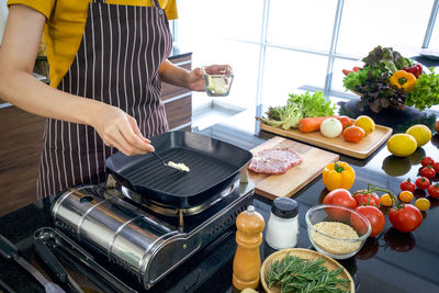 Midsection of man preparing food in kitchen