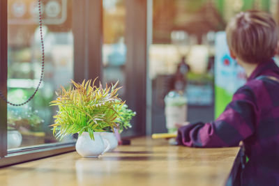 Rear view of boy on table at home