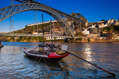 Traditional boat and the dom luis i bridge  over the douro river between porto and vila nova de gaia