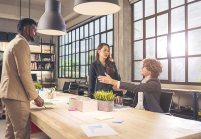 Colleagues in a boardroom discussion, seated at a table together,