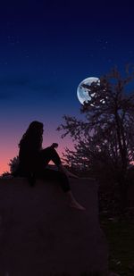 Digital composite image of young woman sitting against blue sky