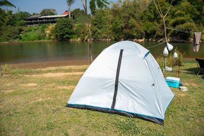 Tent on field by lake