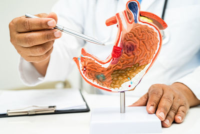 Midsection of dentist examining patient in laboratory